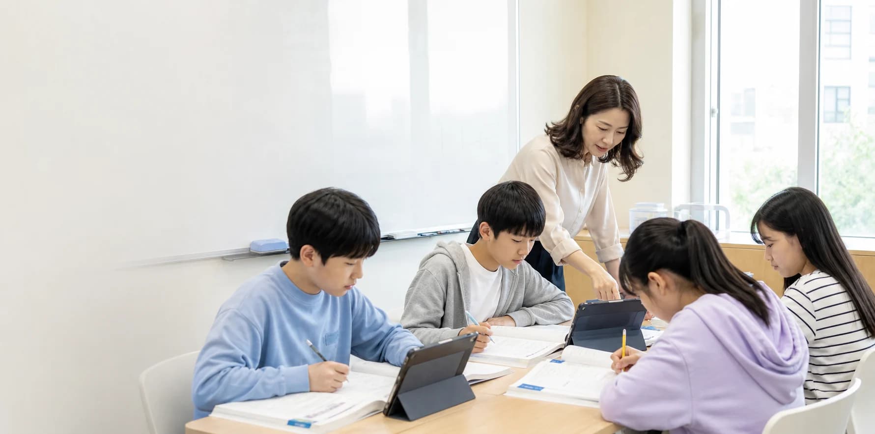 태블릿과 워크북으로 영어수학 블렌디드 수업을 받는 학생들