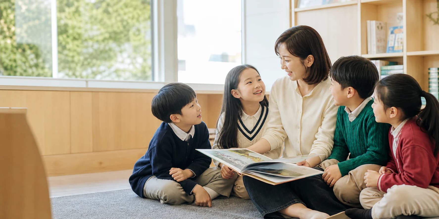 선생님과 영어 그림책을 읽으며 이야기하는 어린이들